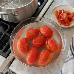 Blanched tomatoes cooling with loosened skins