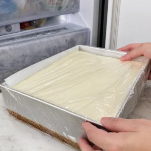 Forma de cheesecake coberta colocada no congelador até ficar firme