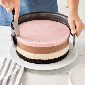 Bolo de sorvete em camadas congelado solto com faca morna enquanto o aro da forma e aberto