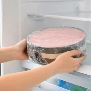 Bolo de sorvete em camadas coberto com filme plastico e colocado no freezer