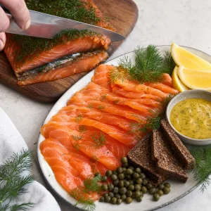 Thinly sliced gravlax served with dill capers lemon rye bread and mustard sauce