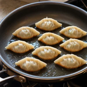 돼지고기 부추 자오쯔를 팬에 납작한 면이 아래로 가게 놓고 바닥이 노릇해질 때까지 굽는 모습