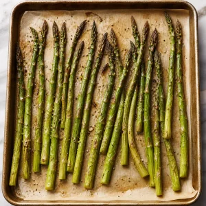Roasted asparagus with lightly charred tips on a baking sheet