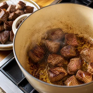 Cubetti di manzo rosolati in olio d oliva in una casseruola per papas con carne.
