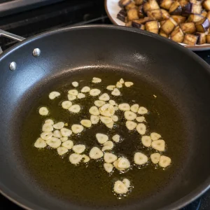 Sliced garlic gently cooking in olive oil
