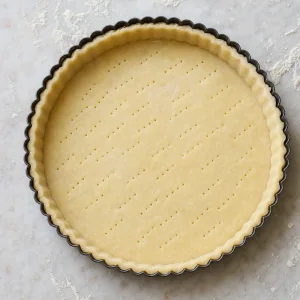 Fond de tarte cru piqué à la fourchette dans un moule cannelé