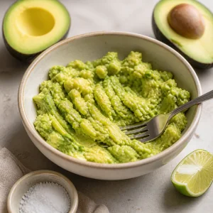 Chunky mashed avocado in a bowl with lime