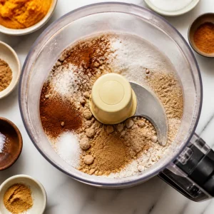 Dry cheesecake ingredients and spices in a food processor
