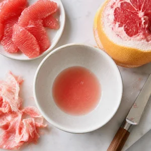 Grapefruitfilets und frischer Grapefruitsaft in einer kleinen Schale
