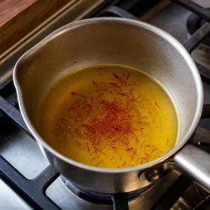 Pistilli di zafferano in infusione nel brodo vegetale caldo.
