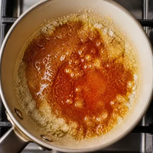 Sugar melting into amber caramel in a saucepan