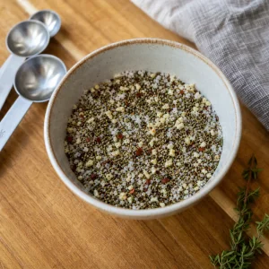 Salt pepper sage thyme red pepper flakes and garlic mixed in a small bowl