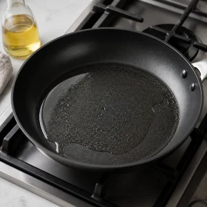 Eine beschichtete Pfanne erhitzt mit einer duennen Schicht Pflanzenoel fuer Kohlpfannkuchen.