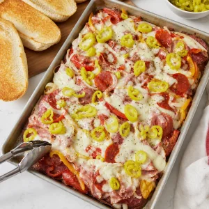 Finished sheet pan Italian sub dinner topped with sliced pepperoncini