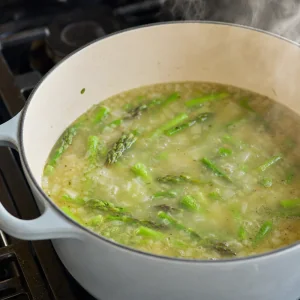 Asparagus soup simmering in vegetable broth until tender