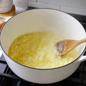 Chopped onion softening in melted butter in a Dutch oven
