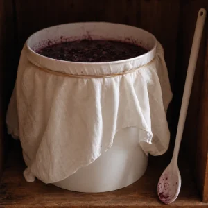 Fermentation bucket covered with breathable cloth in a warm dark place