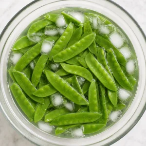 Fresh snow peas soaking in ice water