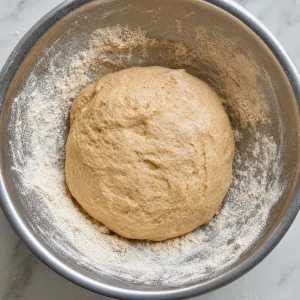 Whole wheat atta dough kneaded in a bowl until soft and smooth.