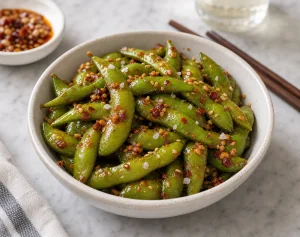 Pikante Knoblauch-Chili-Edamame mit geroestetem Sesam serviert