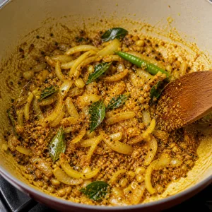 Golden spices stirred into the onion and curry leaf base