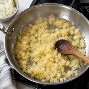 Finely diced onion softens in olive oil in a skillet.