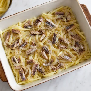 Potato matchsticks layered with softened onions and sprat pieces