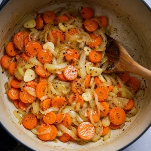 Rondelle di carota e aglio mescolati con cipolle e peperoncino