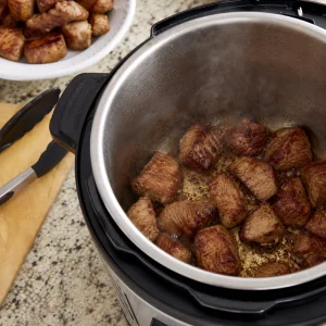 Pork shoulder chunks seared in a pressure cooker until browned
