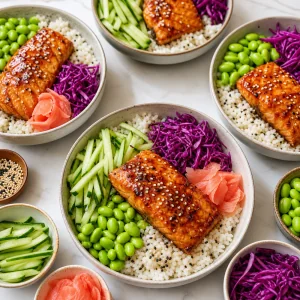 Tigelas de salmão teriyaki montadas com arroz de gergelim pepino repolho roxo edamame e gengibre em conserva