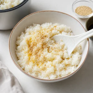 Arroz de grão curto quente misturado com óleo de gergelim e sementes de gergelim branco