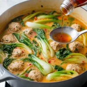 Baby bok choy added to Thai coconut chicken meatball soup.