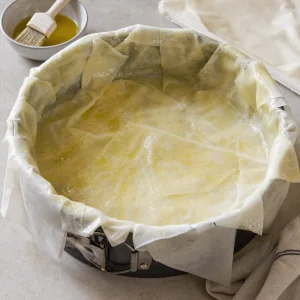 Layered pastry sheets lining a deep pie pan
