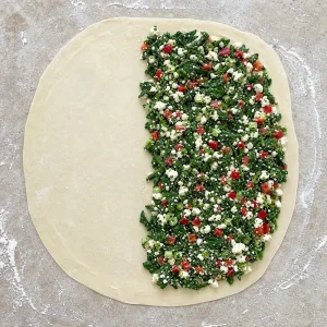 Spinach and feta filling spread over one half of thin gozleme dough