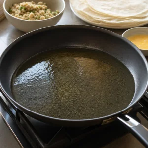 Wide skillet with a shallow layer of shimmering oil ready for frying