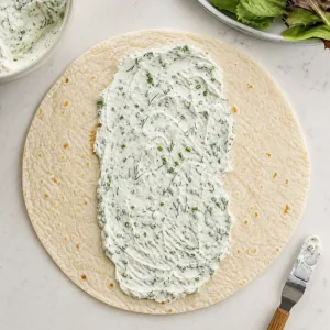 Kraeuterjoghurt mittig auf einer Tortilla verstrichen