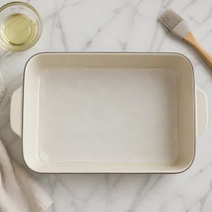 Parchment-lined rectangular baking dish ready for cake batter