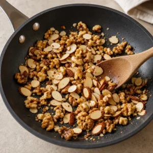Almonds and walnuts toasting in a skillet