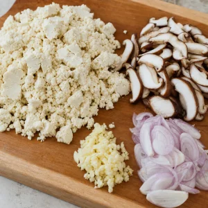 Zerbroeselter Tofu, geschnittene Shiitake, Schalotten und Knoblauch fuer die Fuellung