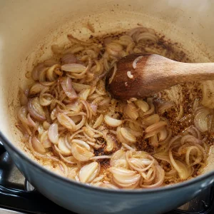Shallots softening in browned pork fond