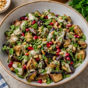 Salada de berinjela coberta com salsa hortela sementes de roma e pinhoes tostados